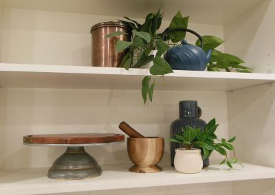 Deco items placed along kitchen shelving